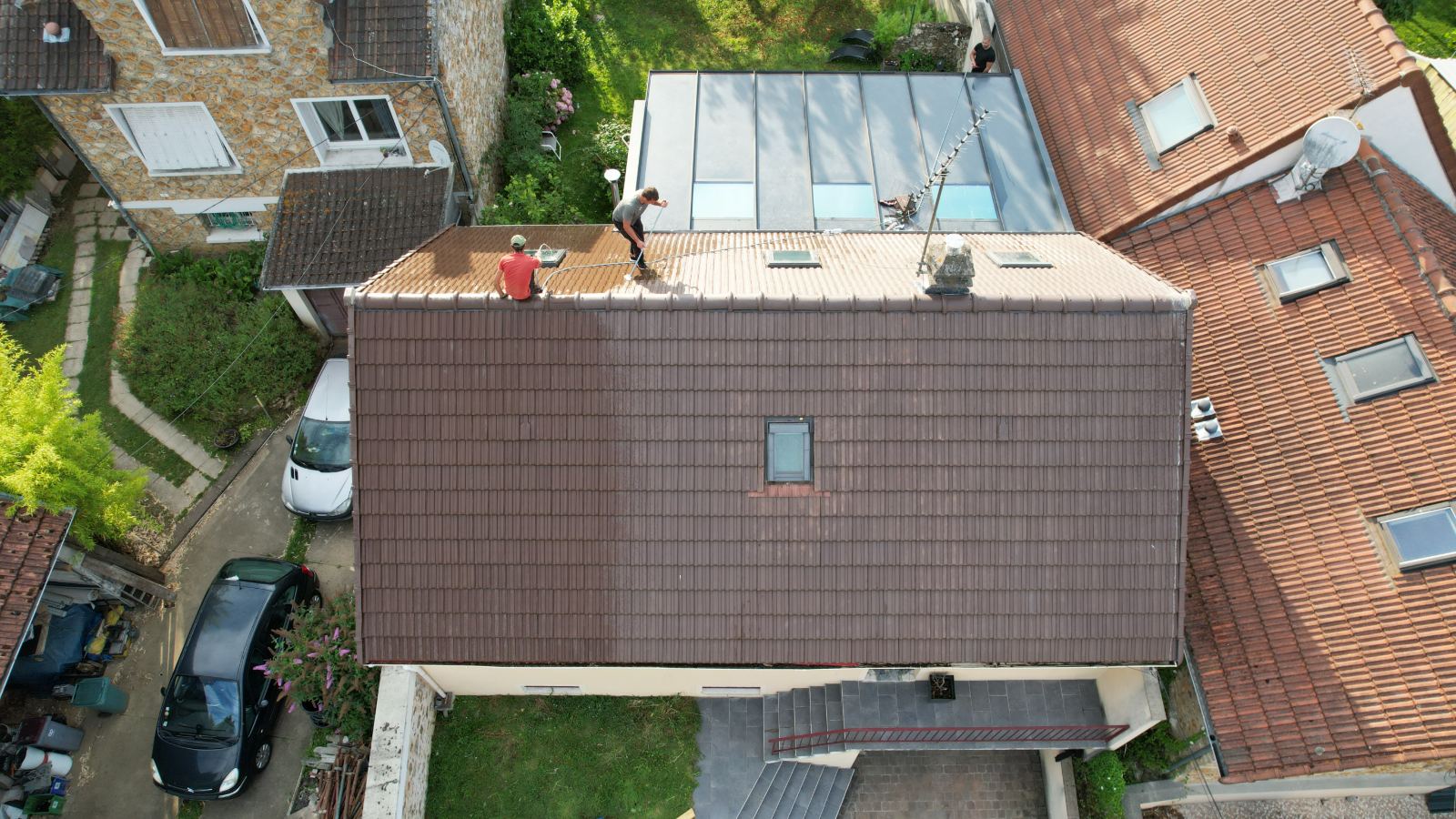 Compagnons couvreurs au travail sur toiture pavillonnaire en tuile, vue drone