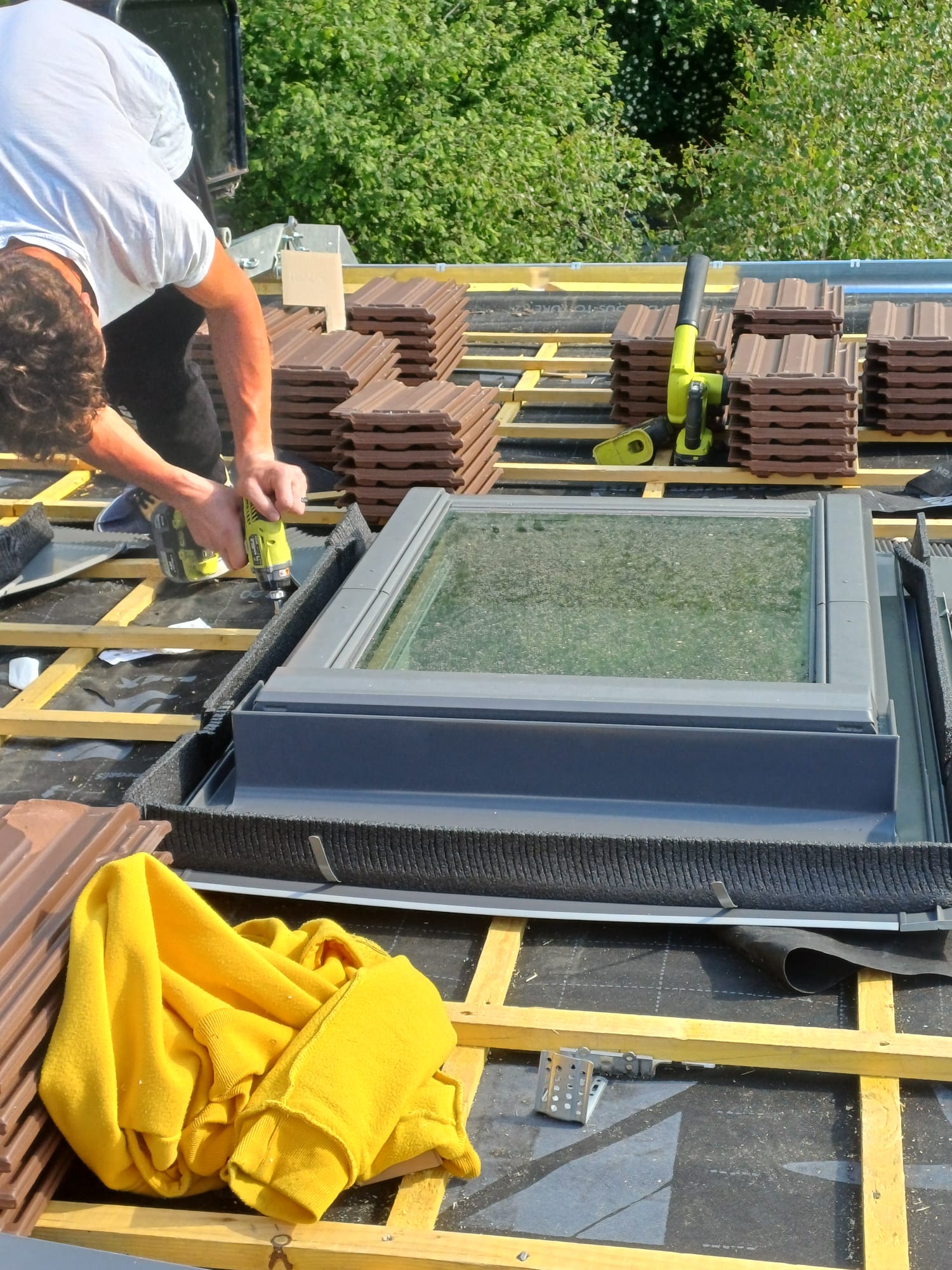 Compagnon en train de visser un velux sur liteaux